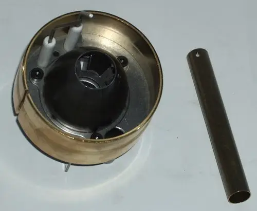 Mischkopf von Daikin, bestehend aus einem runden Gehäuse, einem zentralen Kegel und zwei weißen Stiften, mit einer weiteren runden Metallkomponente daneben.